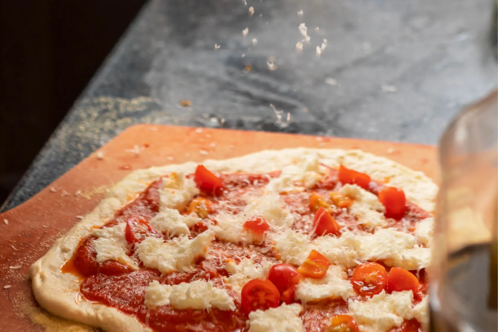Neapolitan‑style pizza class at The Osthoff Resort with students making dough, sauce, and custom toppings using a pizza stone and peel.