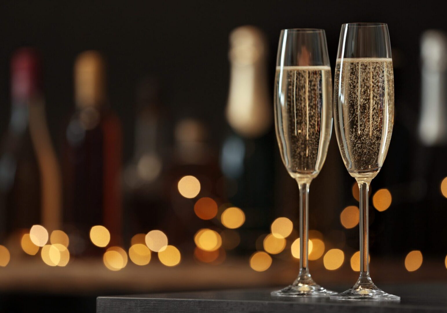 Glasses of champagne on table against blurred background.