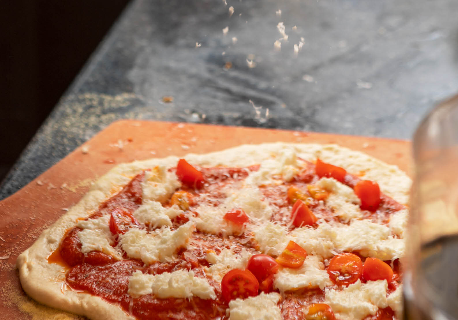 Neapolitan‑style pizza class at The Osthoff Resort with students making dough, sauce, and custom toppings using a pizza stone and peel.