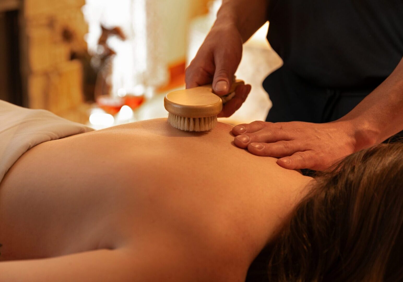 Spa therapist performing a gentle dry brushing treatment on a guest at Aspira Spa, The Osthoff Resort