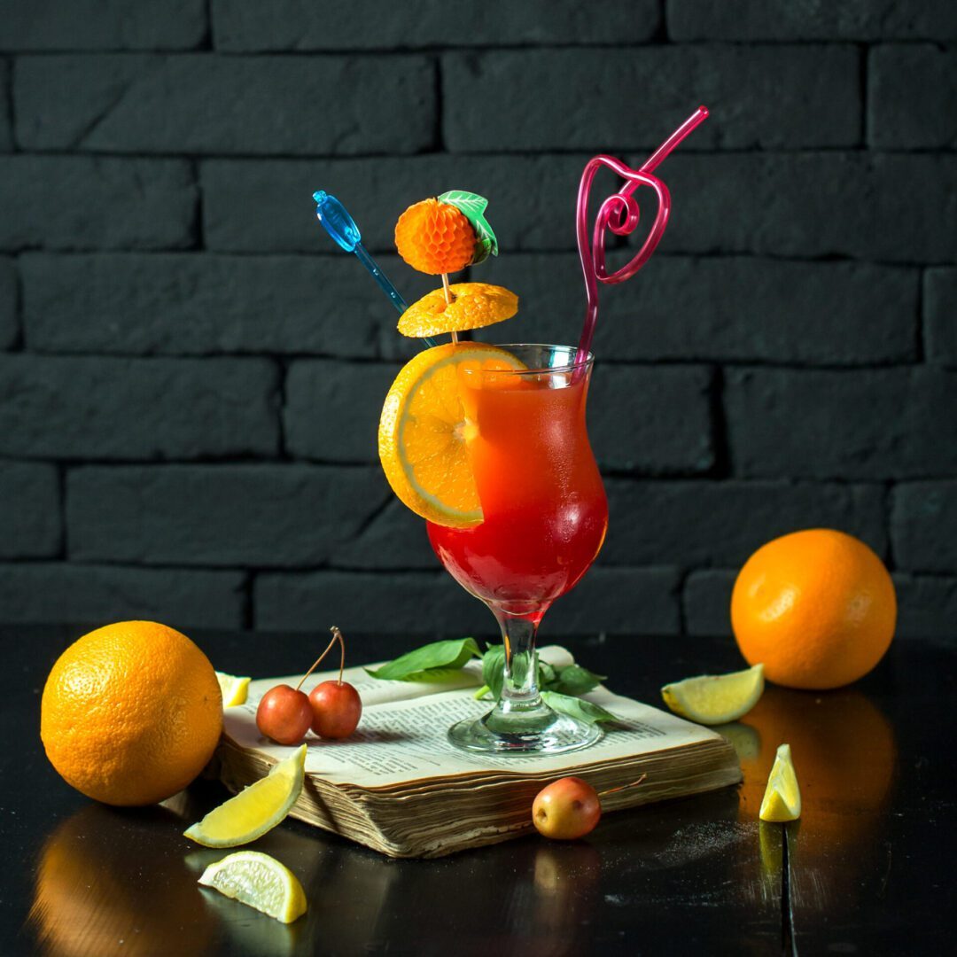 front view cocktail on an open book with a slice of orange in the form of a decor